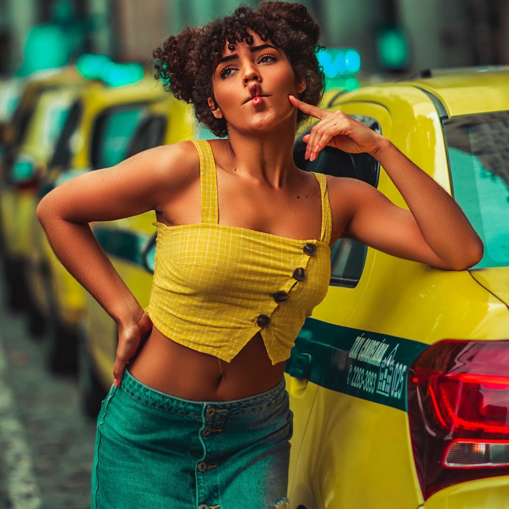 Selective Focus Photography of Woman Pouting Her Lips While Leaning on Taxi