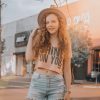 Woman in Crop Top and Denim Shorts Standing Near Storefront