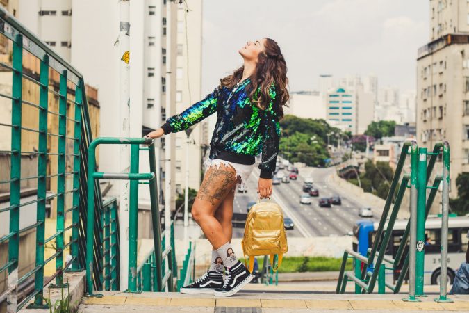 Woman Standing While Holding Gold Backpack Looking Up