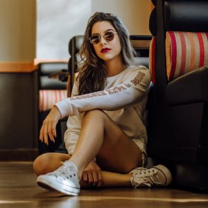 Woman Sitting Near Sofa with Cross Legs