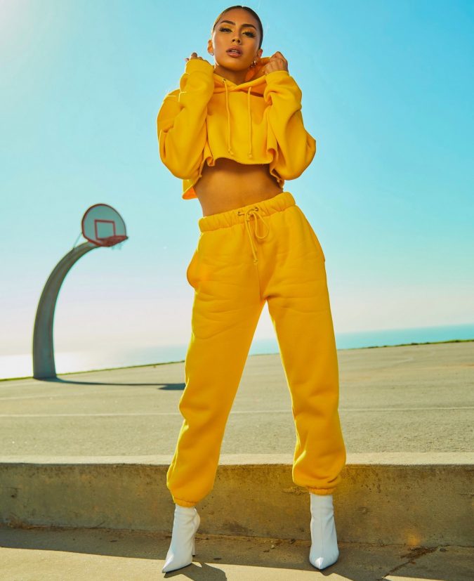 Woman in Yellow Tracksuit Standing On Basketball Court Side